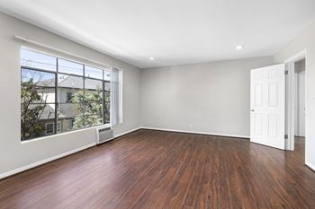 A room with wooden floors and a large window.